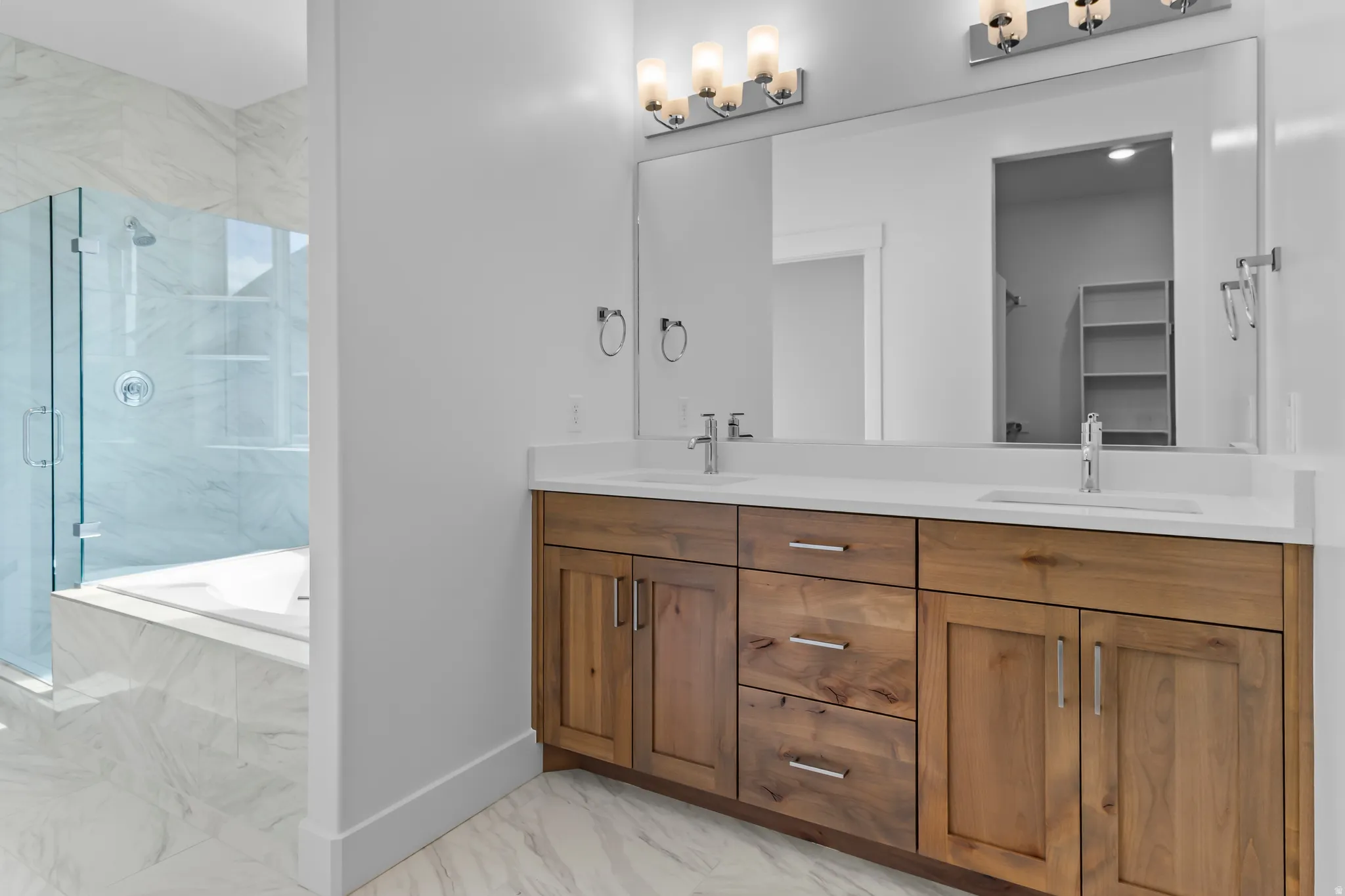 Double vanity featuring wood-finish cabinetry and white countertops