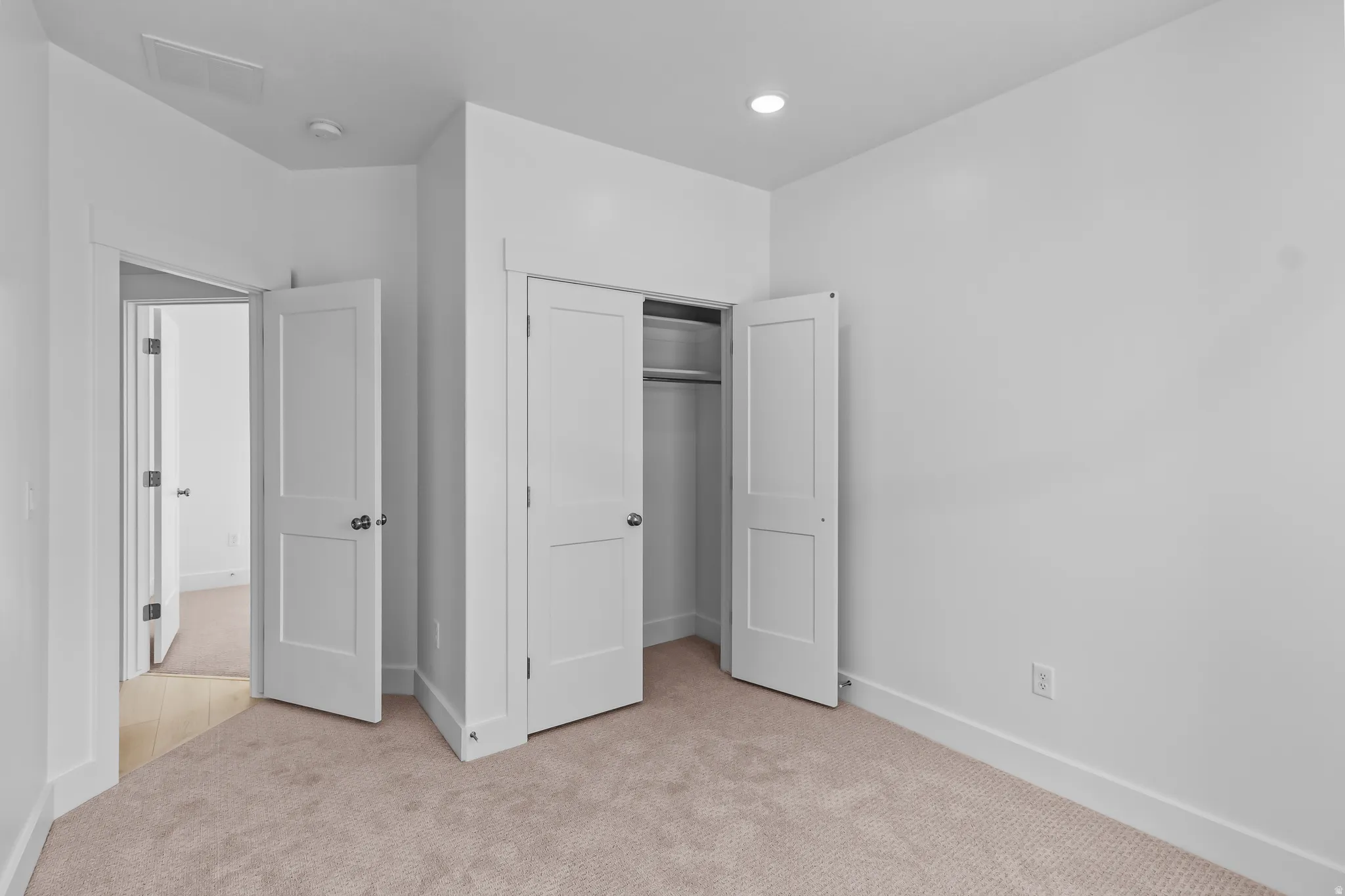 Carpeted room with white walls, recessed lighting, and white trim