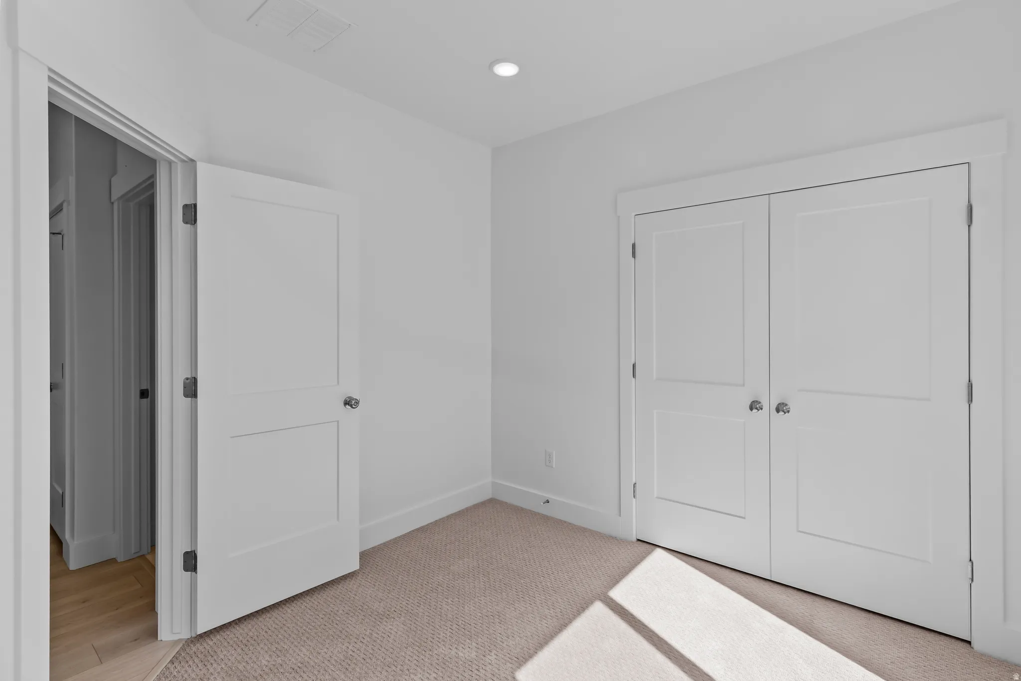 Carpeted room featuring white walls, a recessed ceiling light, and white trim