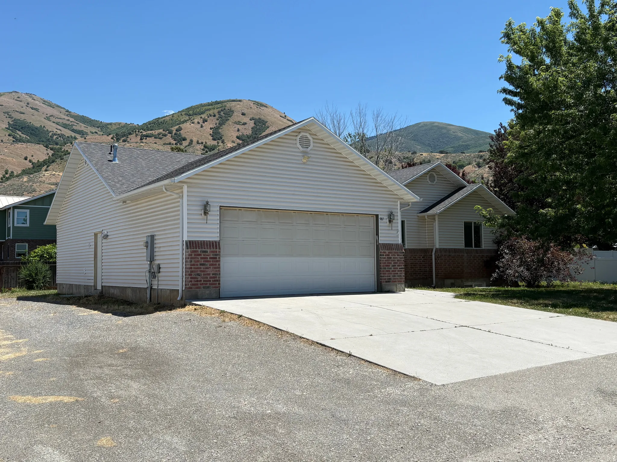 Attached two-car garage with brick veneer accents and a concrete driveway