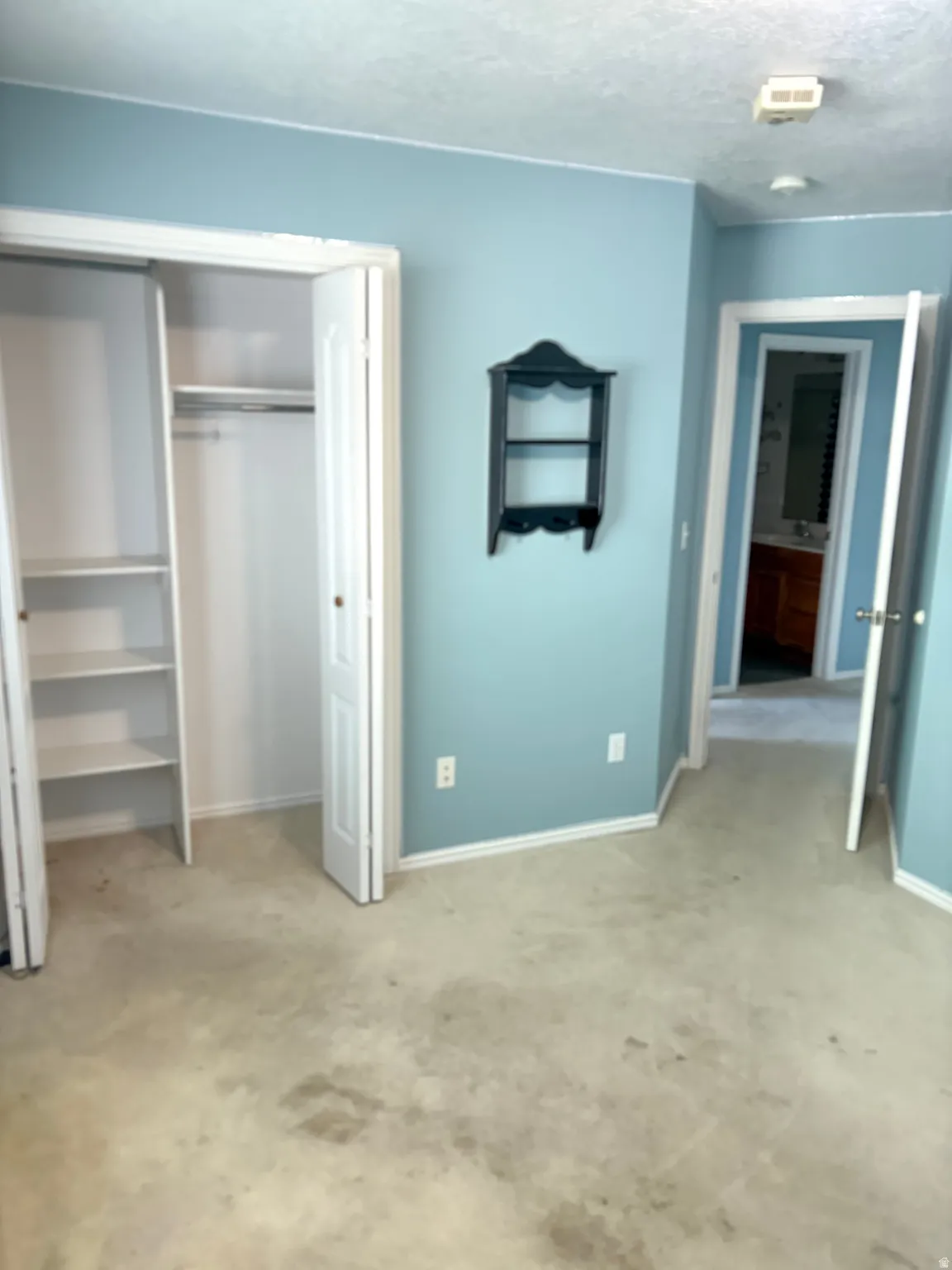Bedroom showing double closet and featuring light blue wall paint and white trim