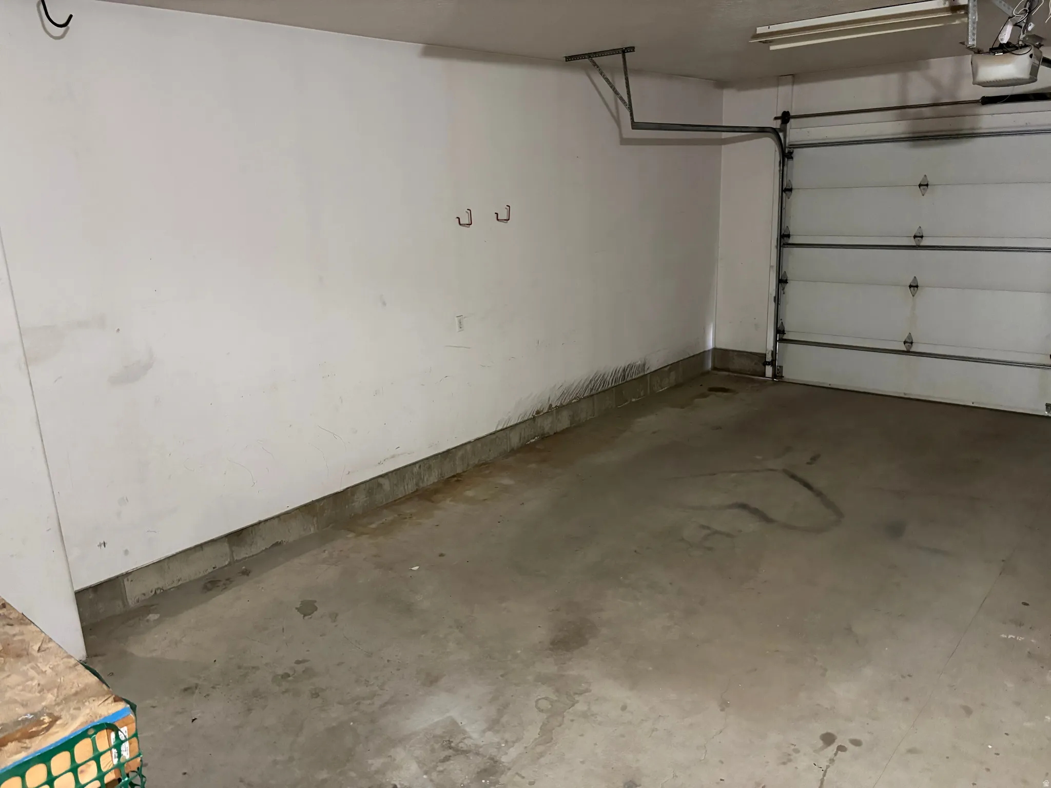 Attached garage featuring a concrete floor, white painted walls, and a sectional garage door