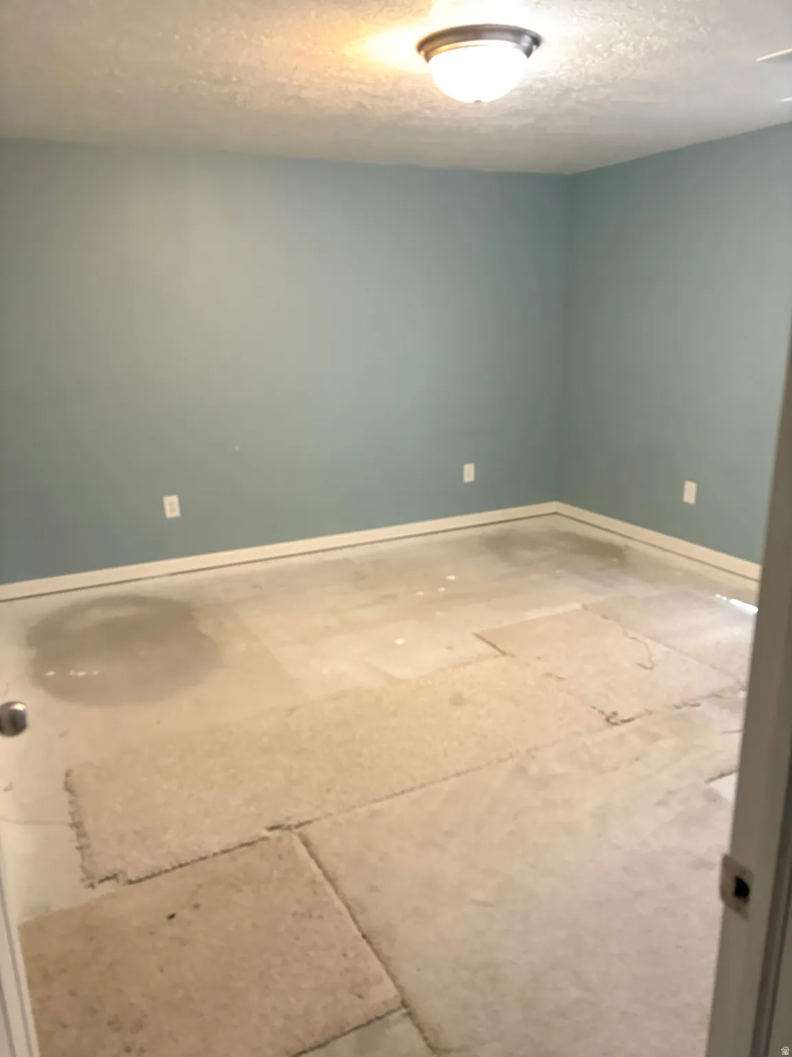Room featuring light blue walls, white baseboards, and a ceiling-mounted light fixture
