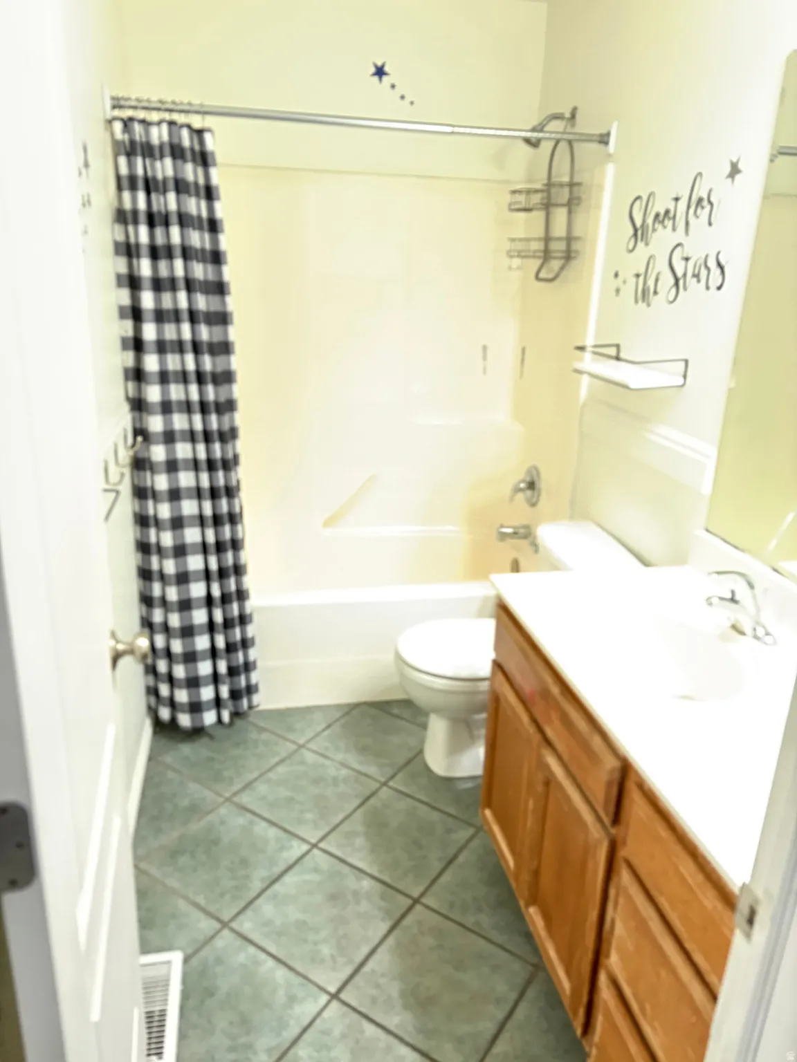 Bathroom featuring a full tub/shower combination, tile flooring, and a vanity with a built-in sink and ample storage