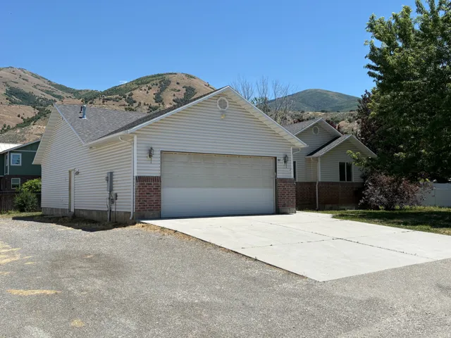Attached two-car garage with brick veneer accents and a concrete driveway