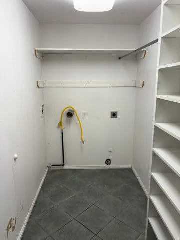 Laundry area featuring tiled flooring, built-in shelving, a clothes rod, and utility hookups