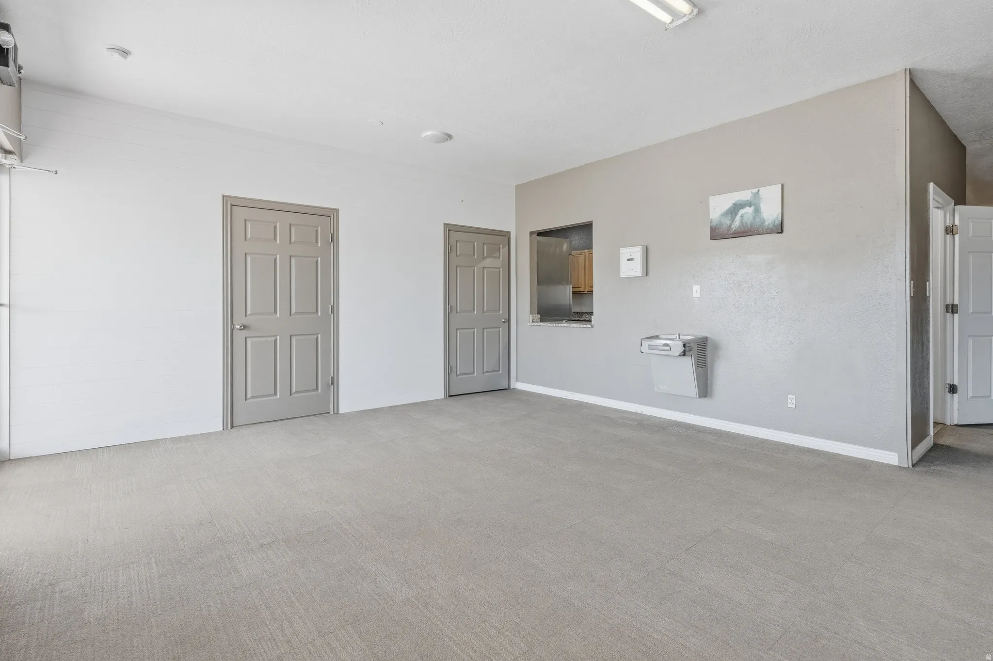 Spacious interior space featuring a concrete floor, recessed lighting, and multiple panel doors