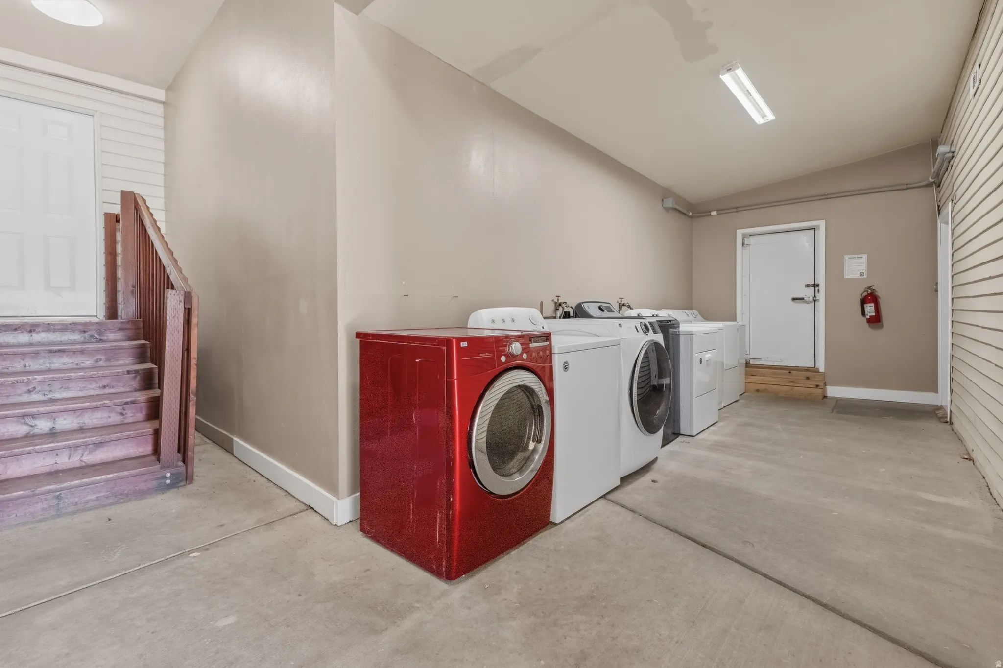 Laundry area with concrete flooring, neutral wall paint, and multiple appliance hookups