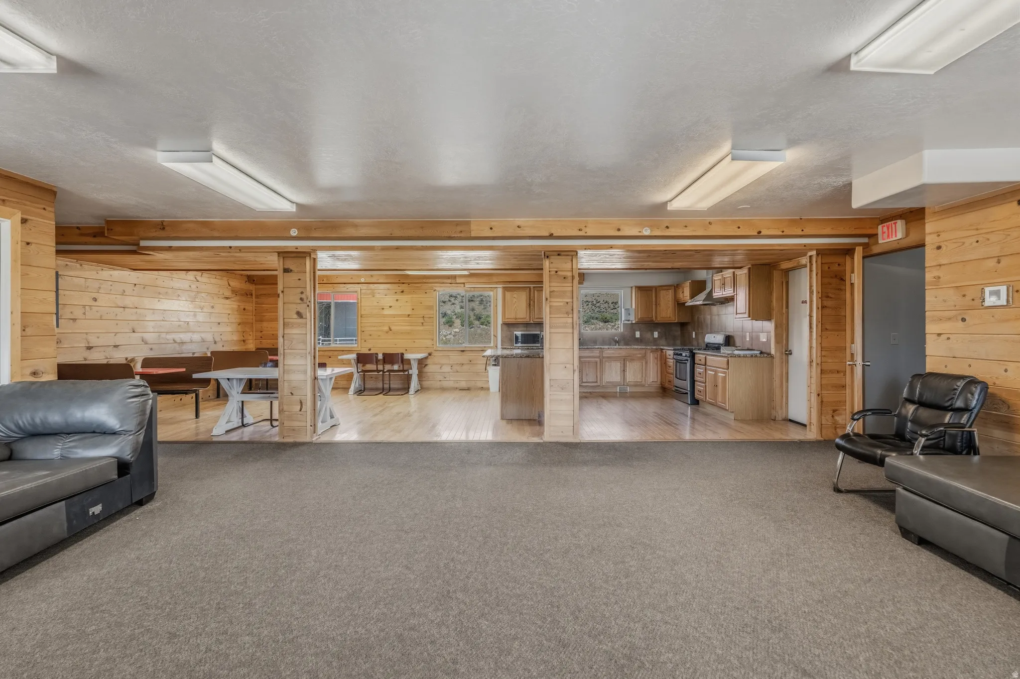 Spacious interior with carpeted flooring in the foreground and wood-finish flooring beyond