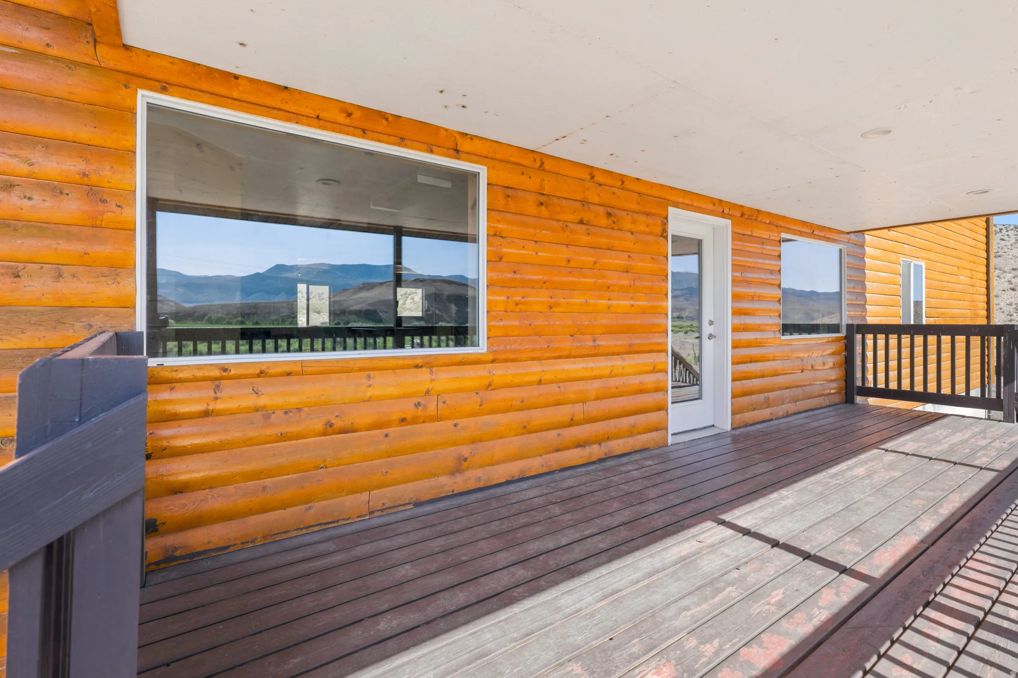 Expansive outdoor deck featuring wood-finish flooring and a wood-paneled exterior