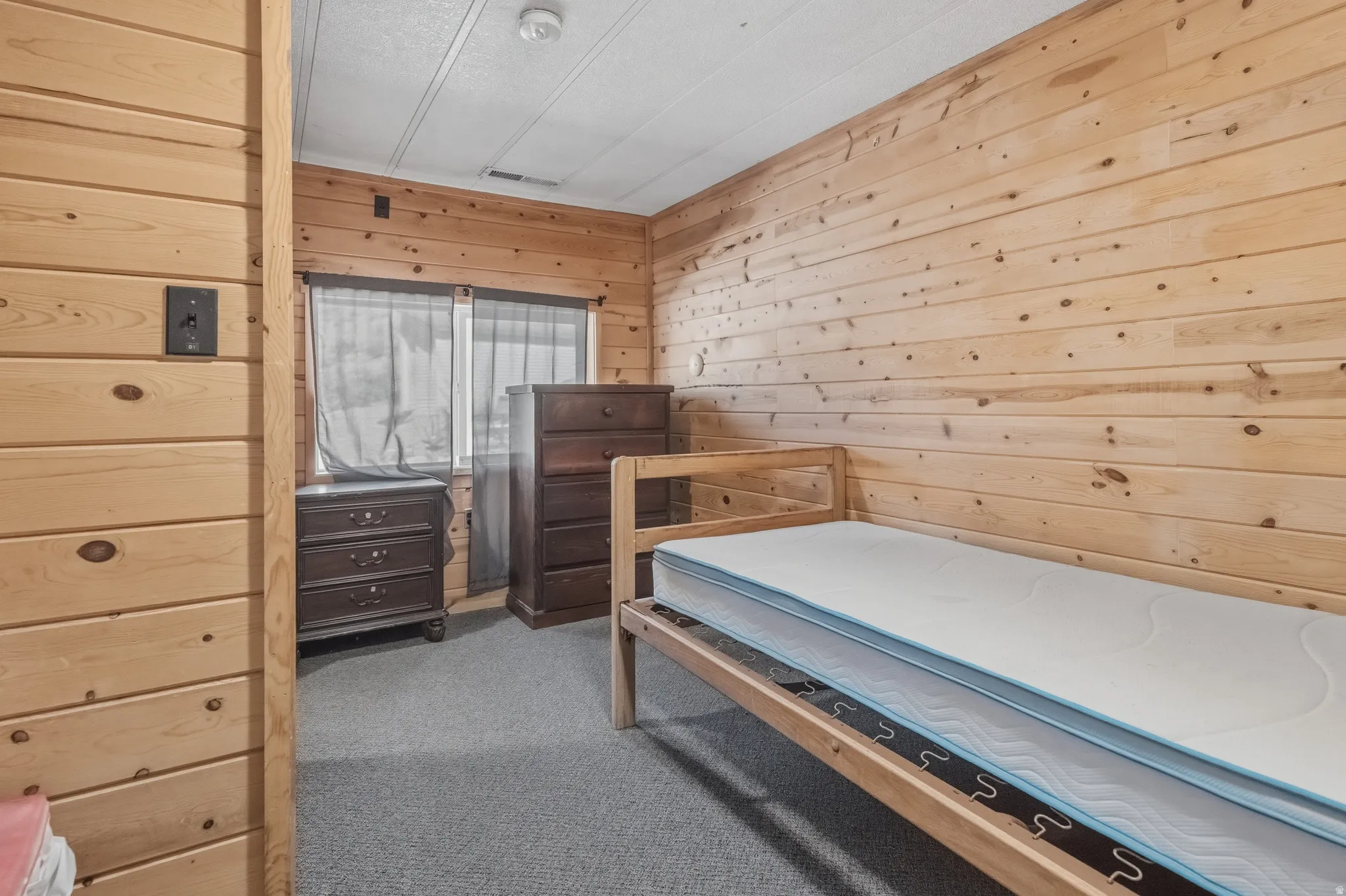 Room featuring horizontal wood paneling, gray carpet flooring, and a white ceiling