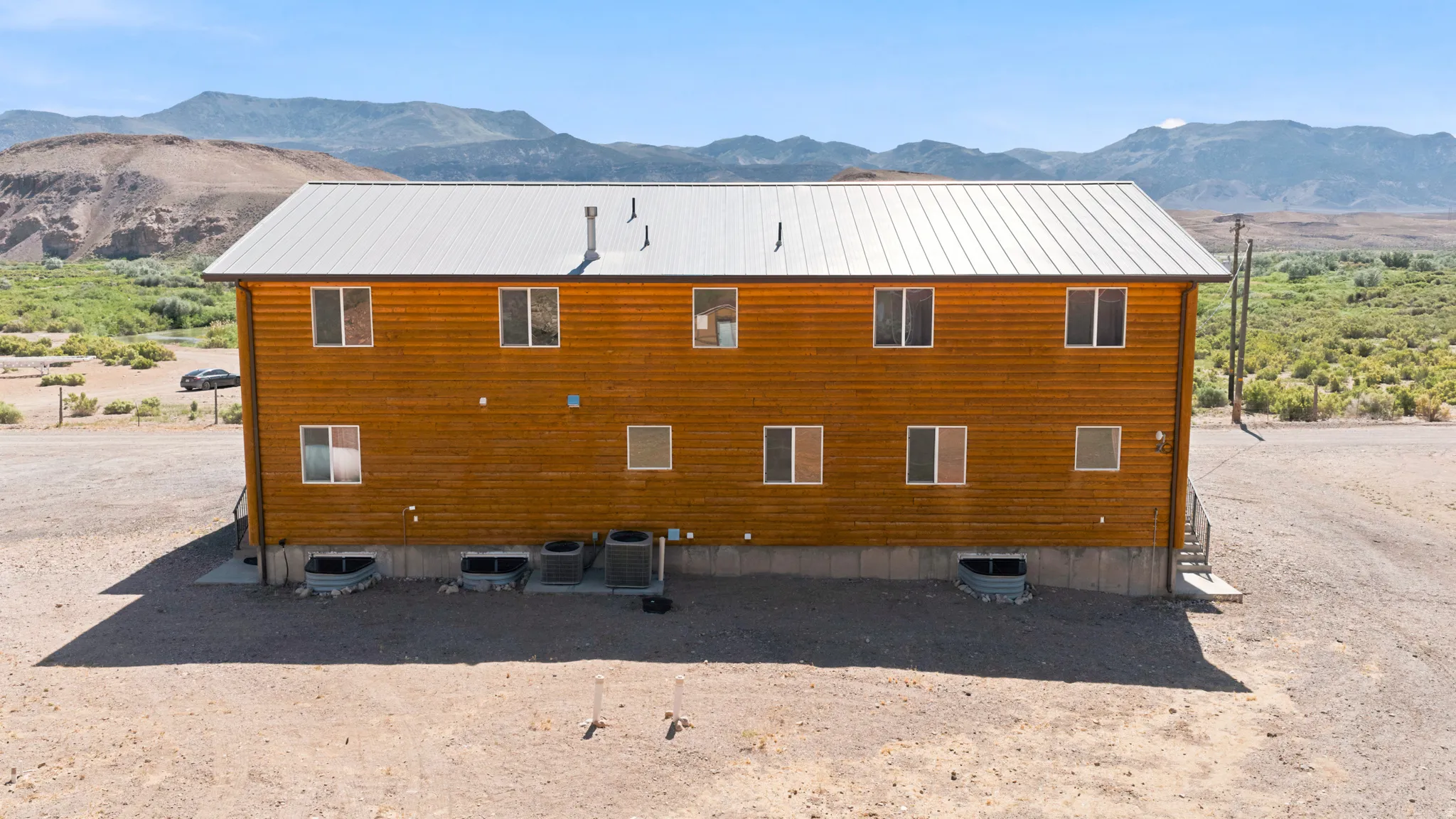 Two-story structure featuring wood-finish siding and a metal roof
