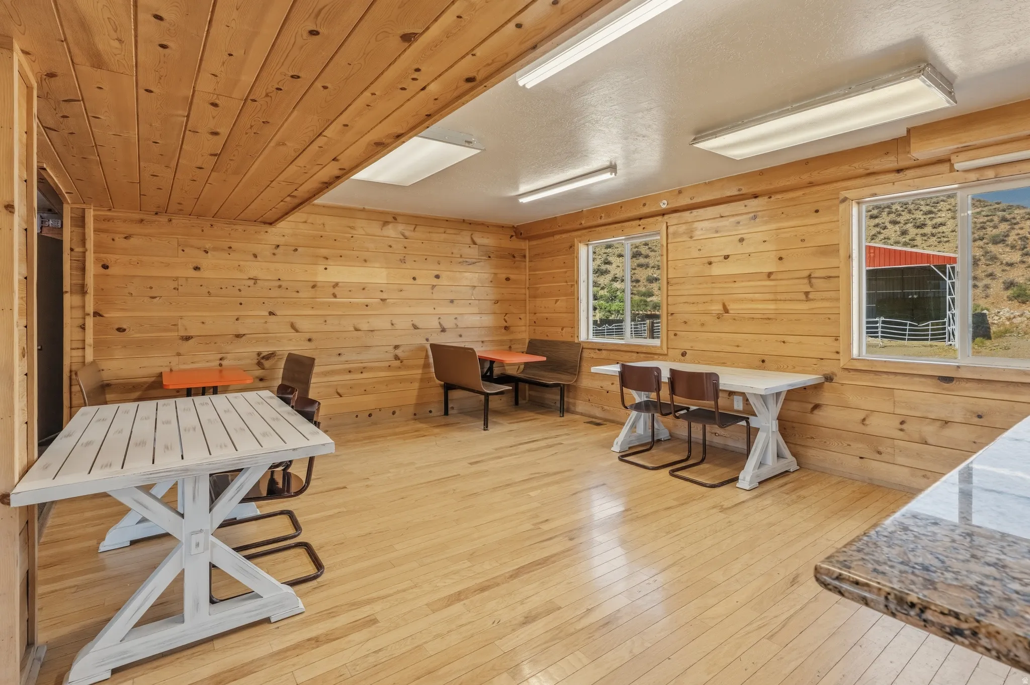 Expansive room featuring natural wood plank walls and ceilings