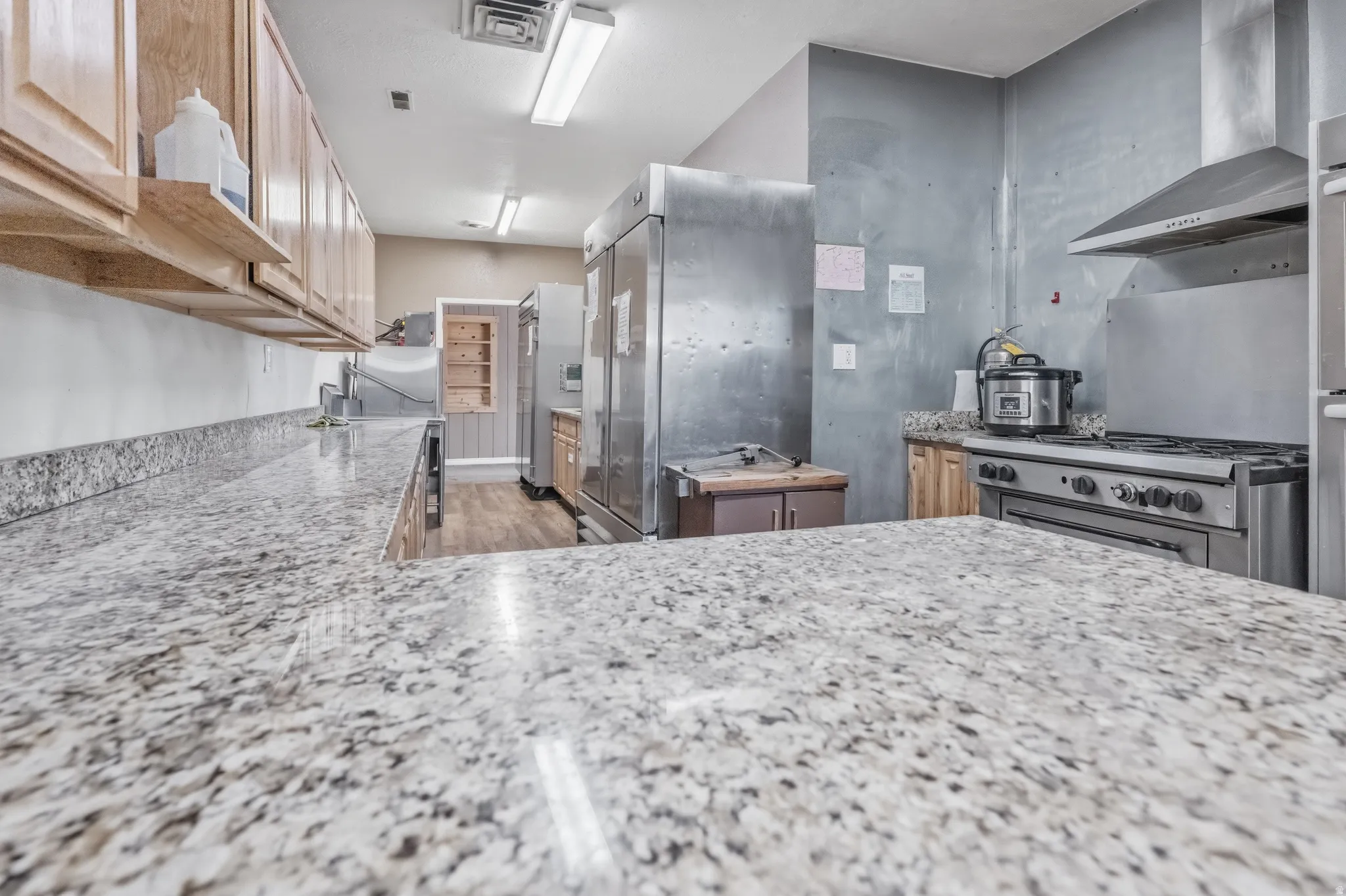 Expansive stone countertops with light wood-finish cabinetry