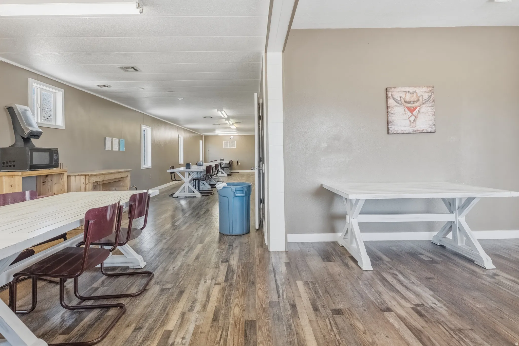 Spacious room featuring wood-finish flooring and light-toned walls