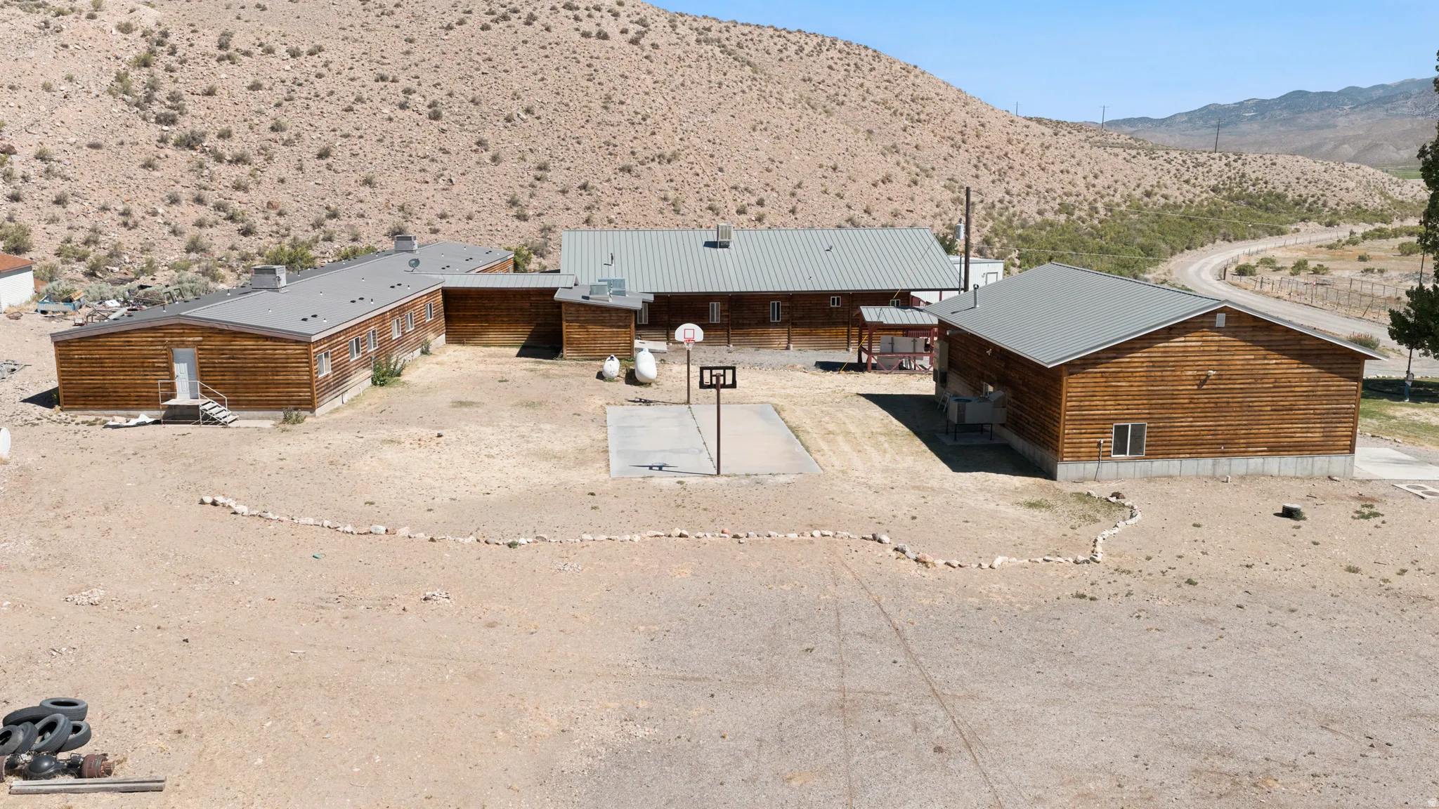 Expansive desert property featuring multiple wood-sided structures with metal roofs