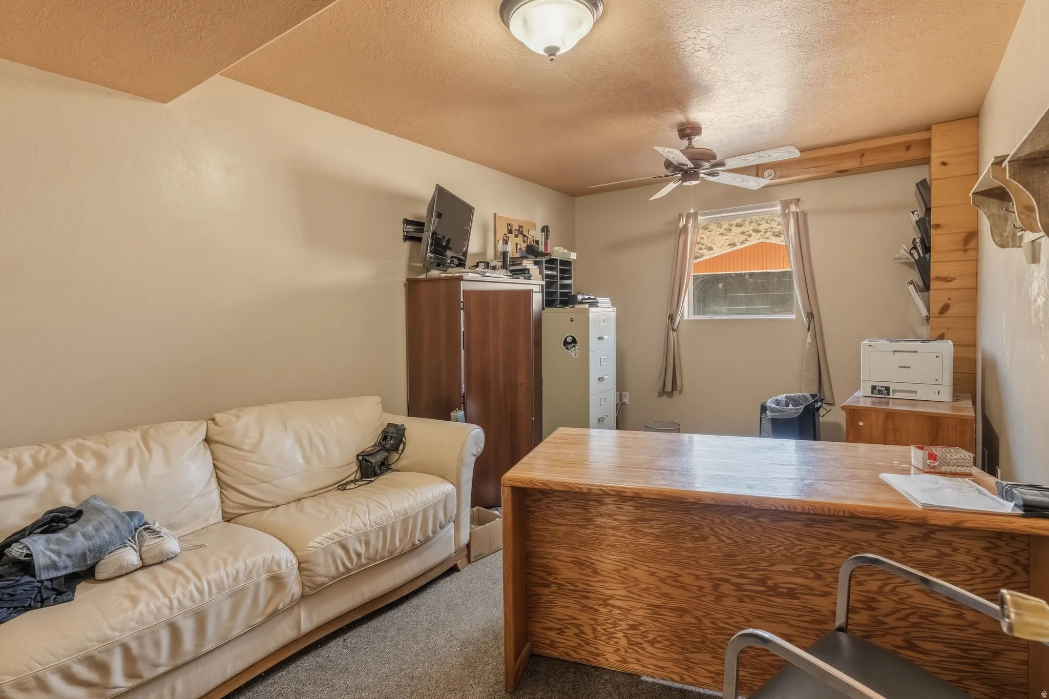 Functional room featuring ceiling-mounted lighting, a ceiling fan, and a window with natural light