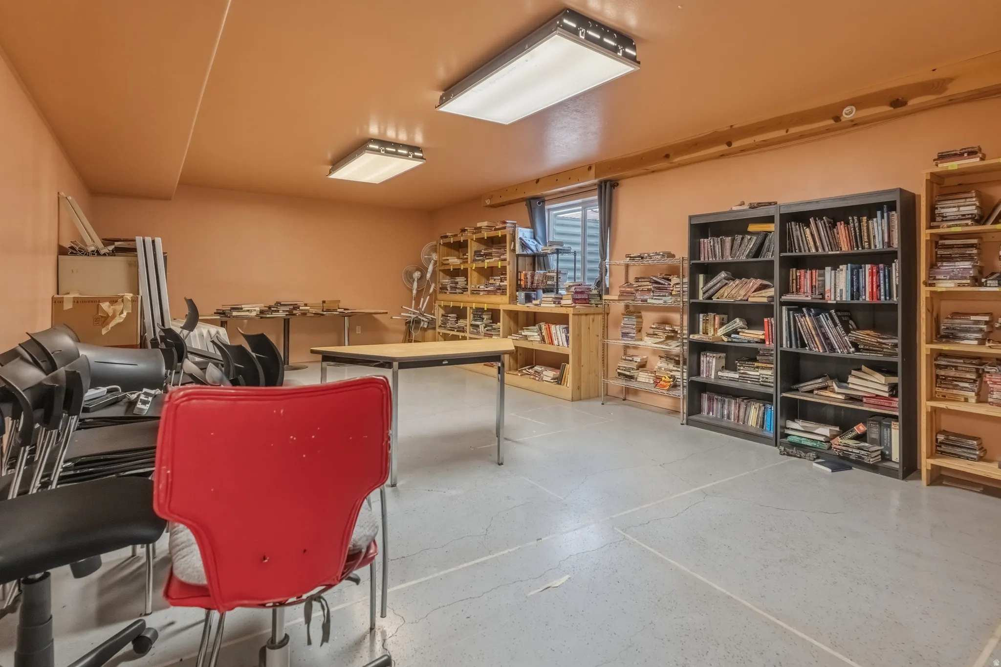 Spacious room with concrete flooring and light orange walls