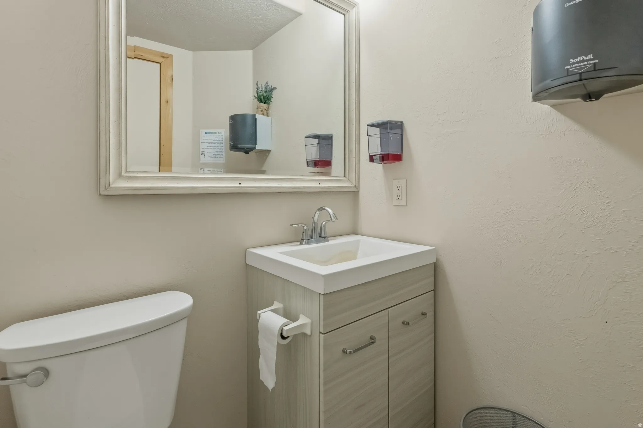 White toilet with a wall-mounted paper holder
