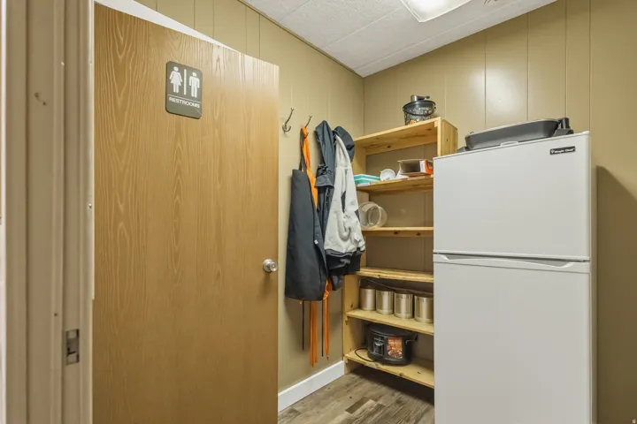 Wood-finish door with a silver knob and restroom signage