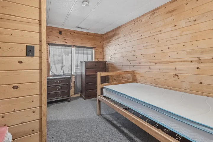 Room featuring horizontal wood paneling, gray carpet flooring, and a white ceiling