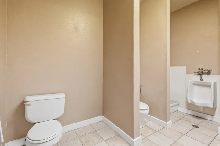 Bathroom featuring neutral-toned walls, white baseboards, and square floor tiles