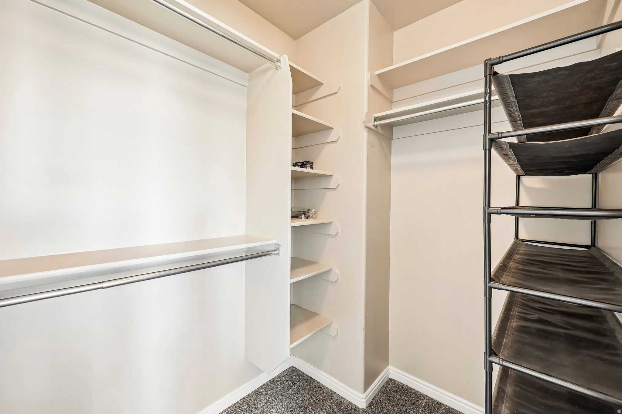 Spacious closet featuring multiple hanging rods, built-in shelving, and neutral wall paint