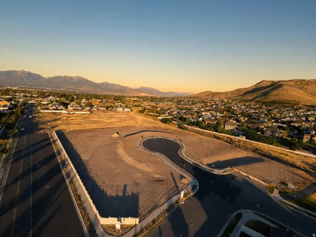 Expansive undeveloped land featuring paved roads and curb infrastructure