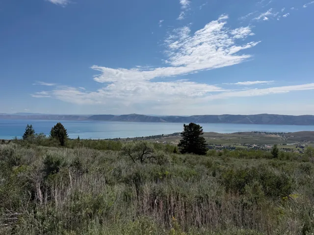 Expansive landscape featuring distant water and mountains under a clear sky