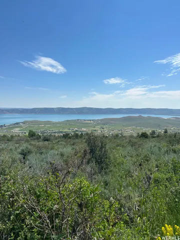 Expansive natural landscape featuring a prominent body of water bordered by distant hills