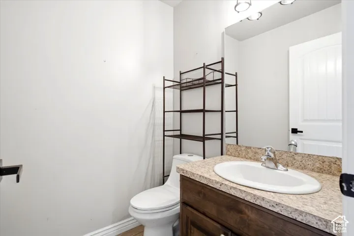 Built-in vanity with a granite-style countertop, undermount sink, and wood-finish cabinetry