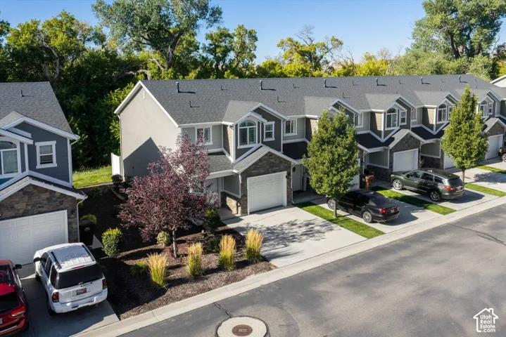 Contemporary townhome exterior with multiple gables, stone accents, and an attached single-car garage