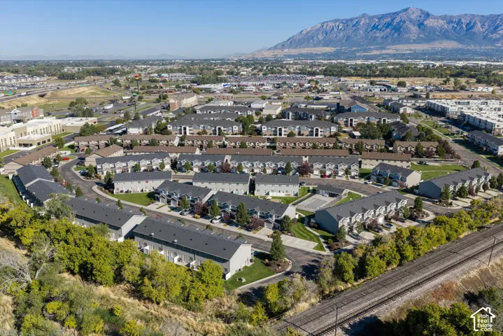 Aerial perspective showcasing a residential community with multi-story buildings, dark pitched roofs, and manicured landscaping
