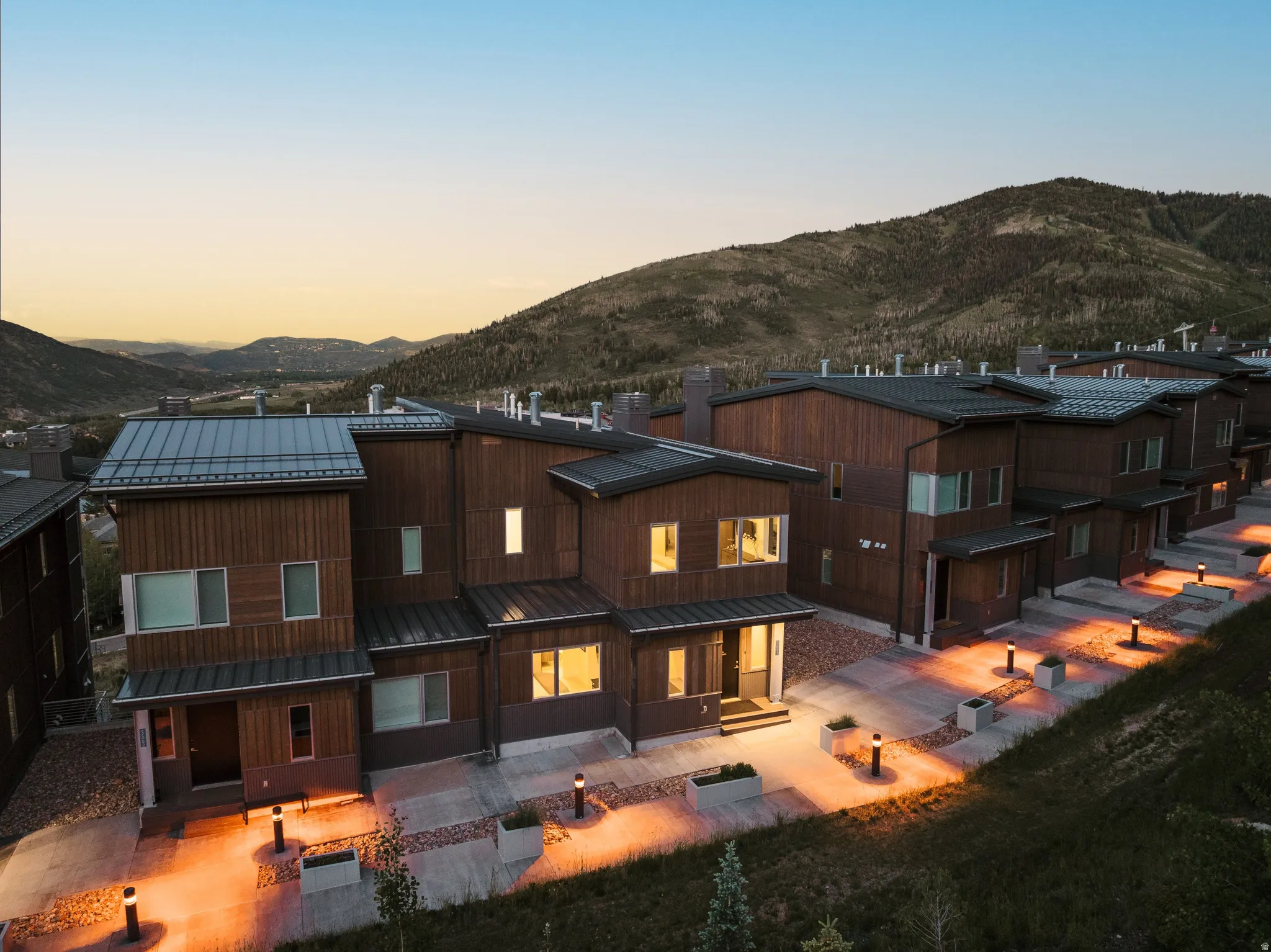 Contemporary multi-level residences featuring wood-finish siding, dark trim, and metal roofing
