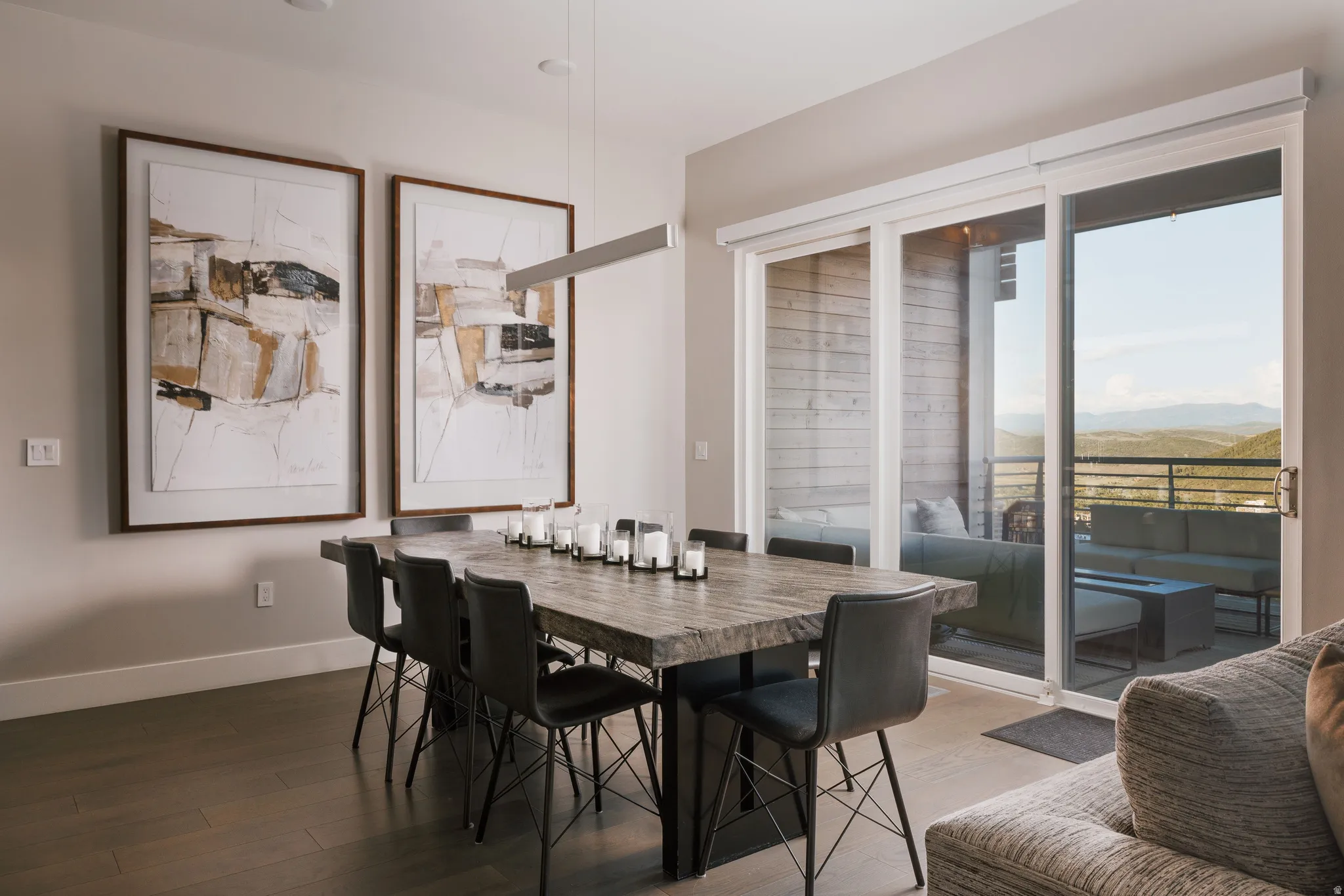 Spacious dining area featuring wood-finish flooring and a linear pendant light fixture