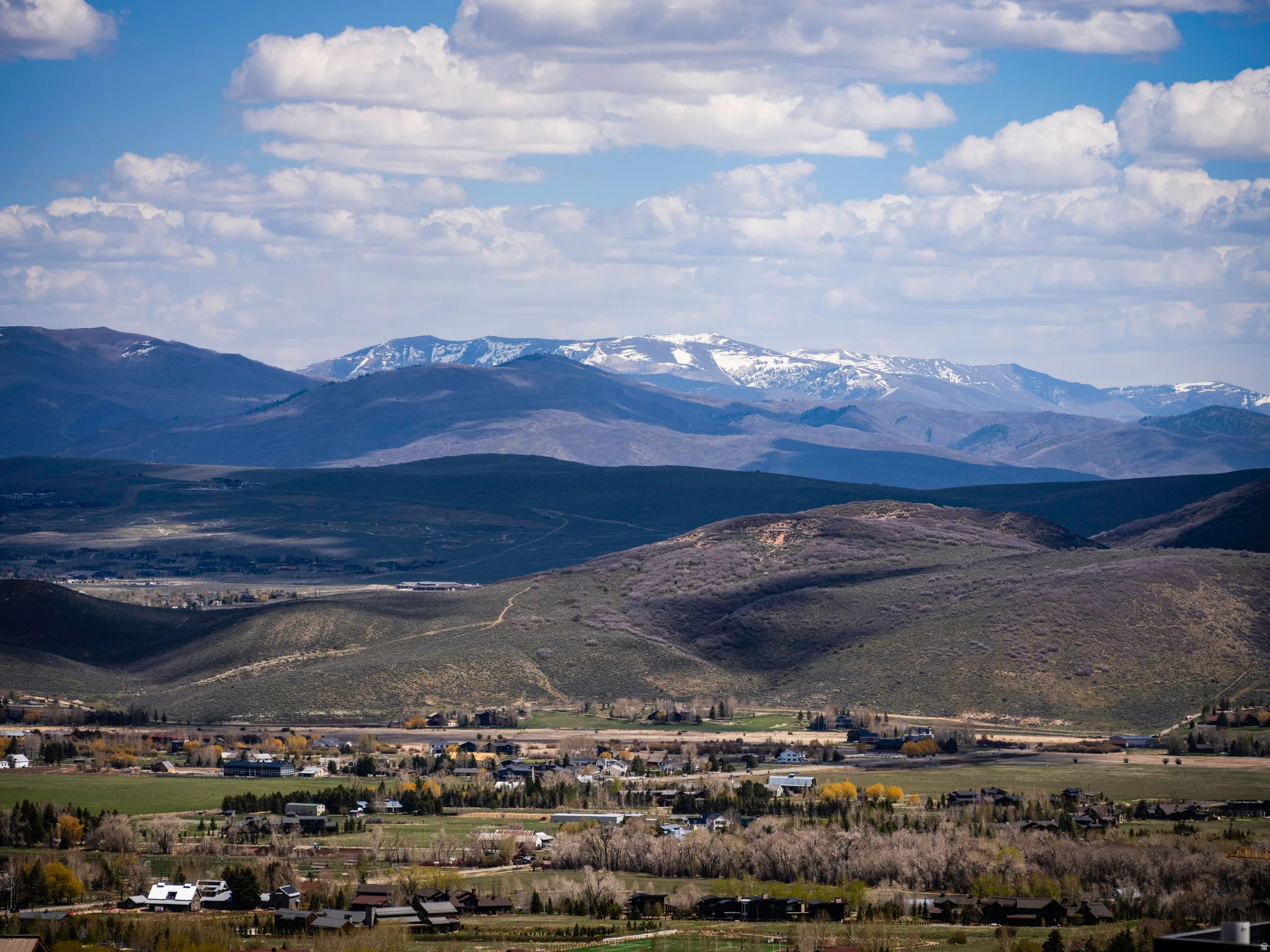Expansive mountain range backdrop with distant snow-capped peaks