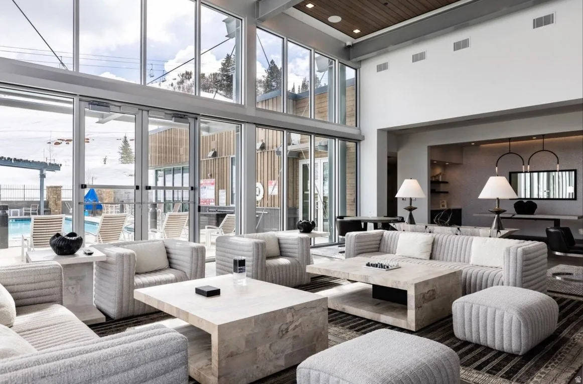 Spacious common area featuring a soaring ceiling, floor-to-ceiling windows, and a wood-finish ceiling accent