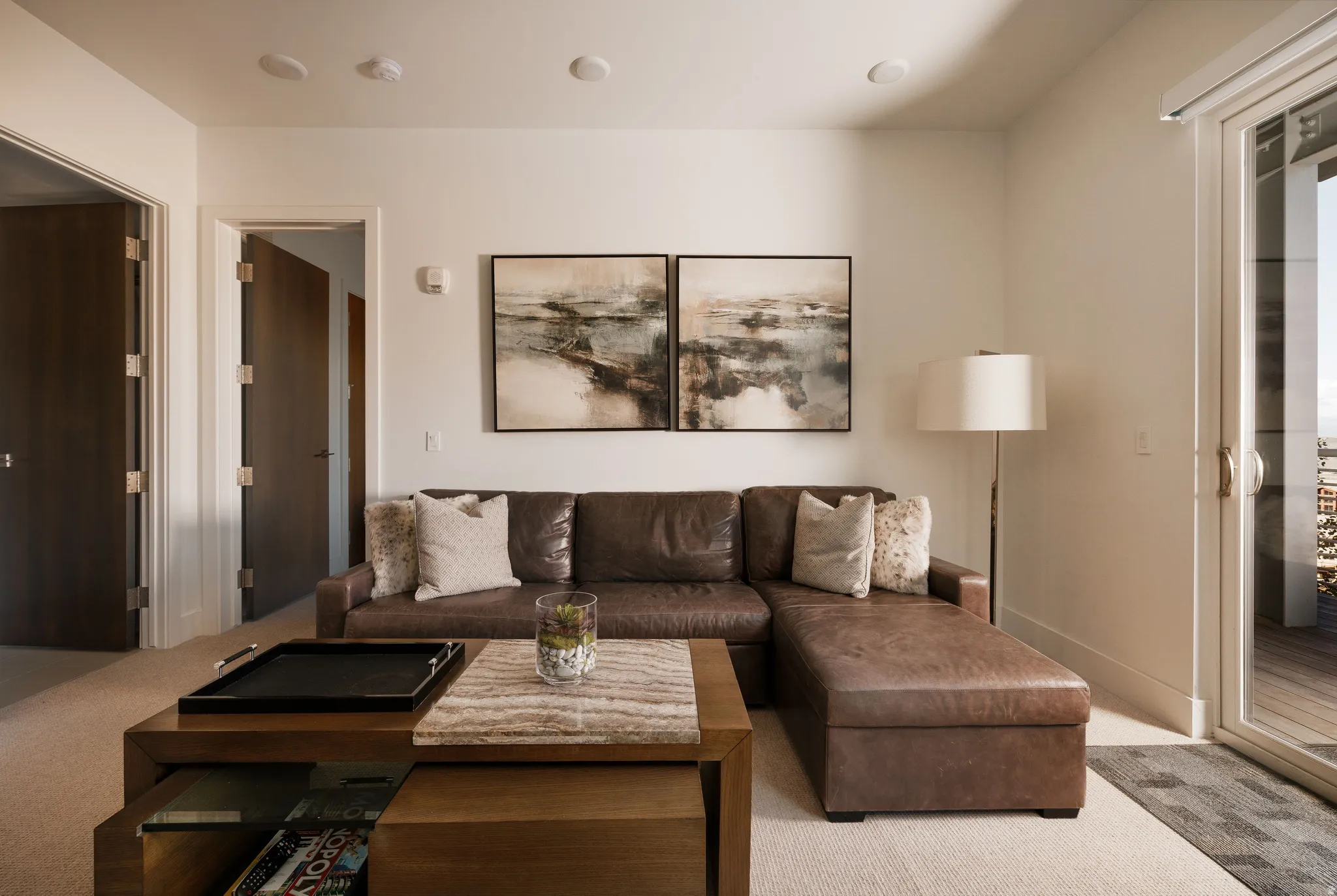 Living area featuring light-colored walls and carpet flooring