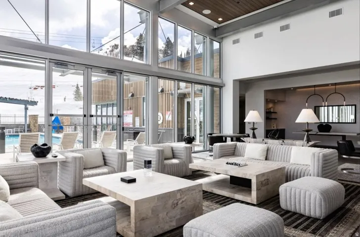Spacious common area featuring a soaring ceiling, floor-to-ceiling windows, and a wood-finish ceiling accent