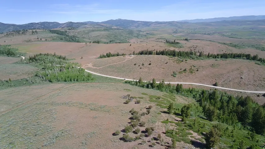 Expansive rural landscape featuring rolling hills and distant mountains