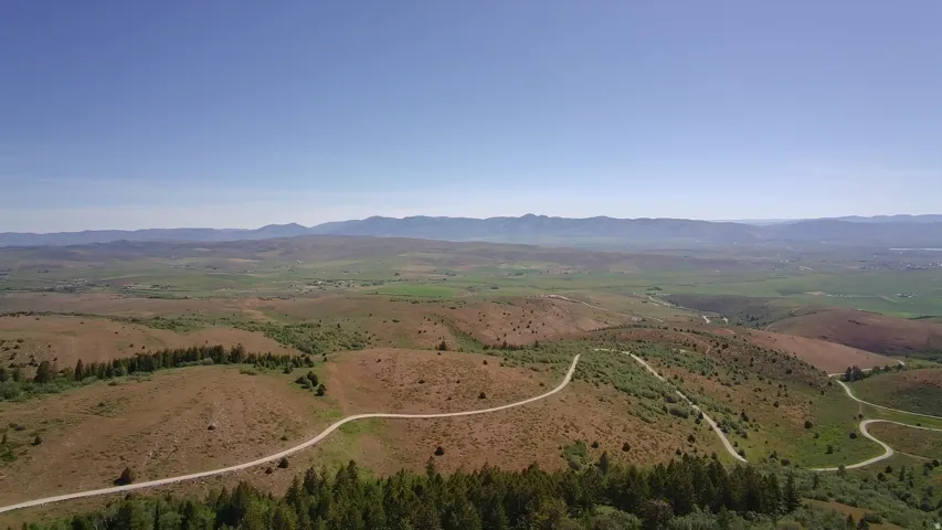 Expansive rural landscape featuring rolling hills and distant mountains