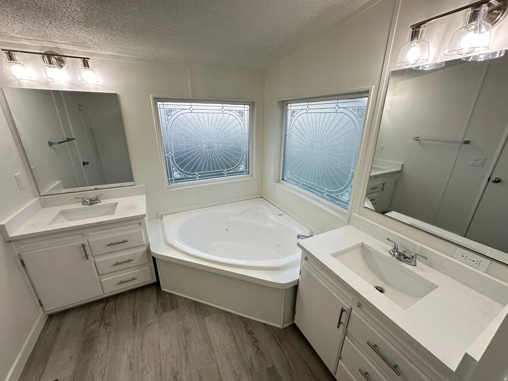 Corner soaking tub with decorative privacy windows