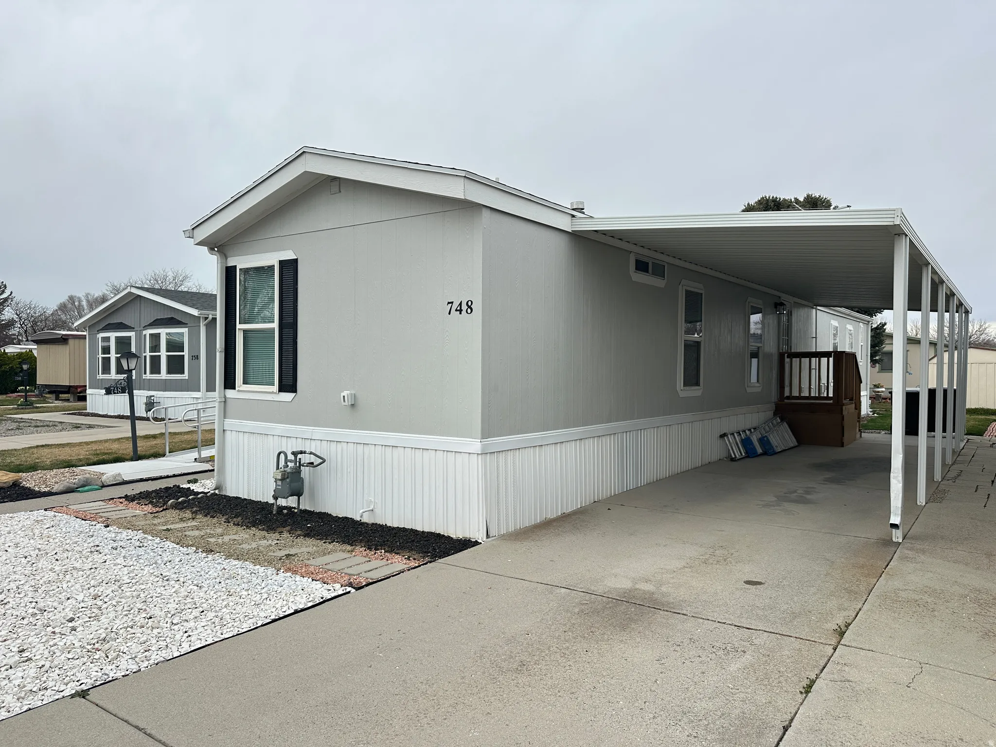 Single-story residence featuring light gray siding and white trim
