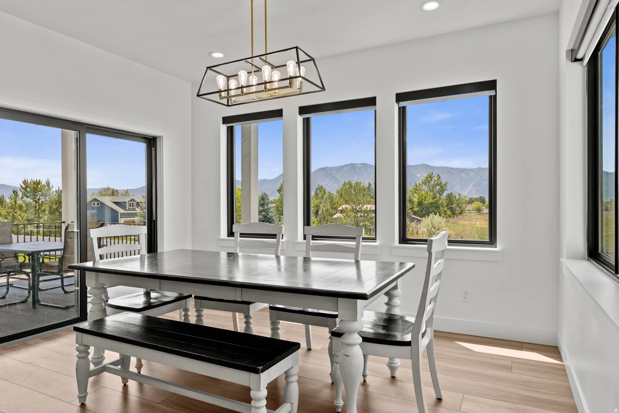 Dining area featuring wood-finish flooring and a contemporary linear chandelier