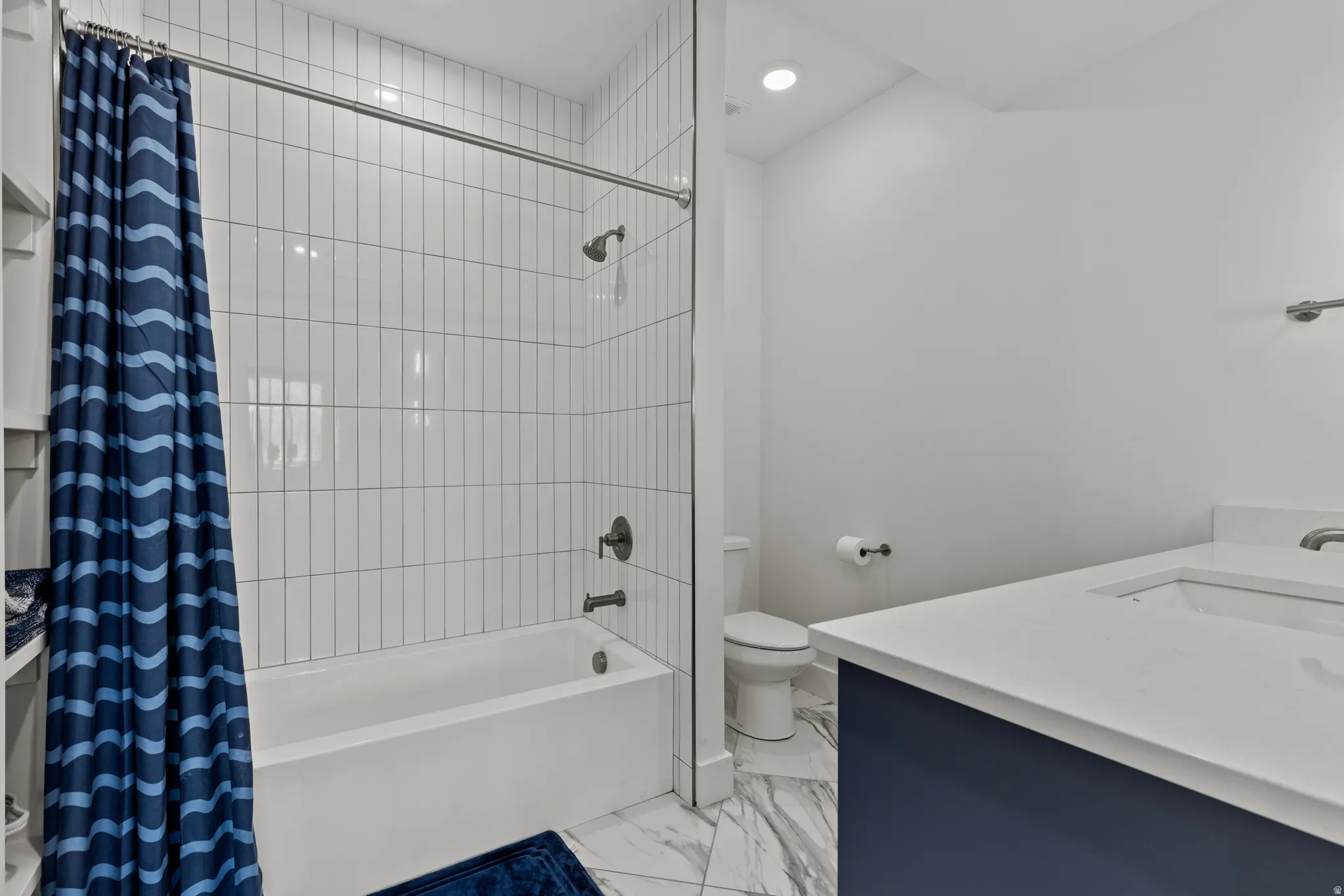 Bathroom featuring a white subway tile surround tub and shower combination with matte black fixtures