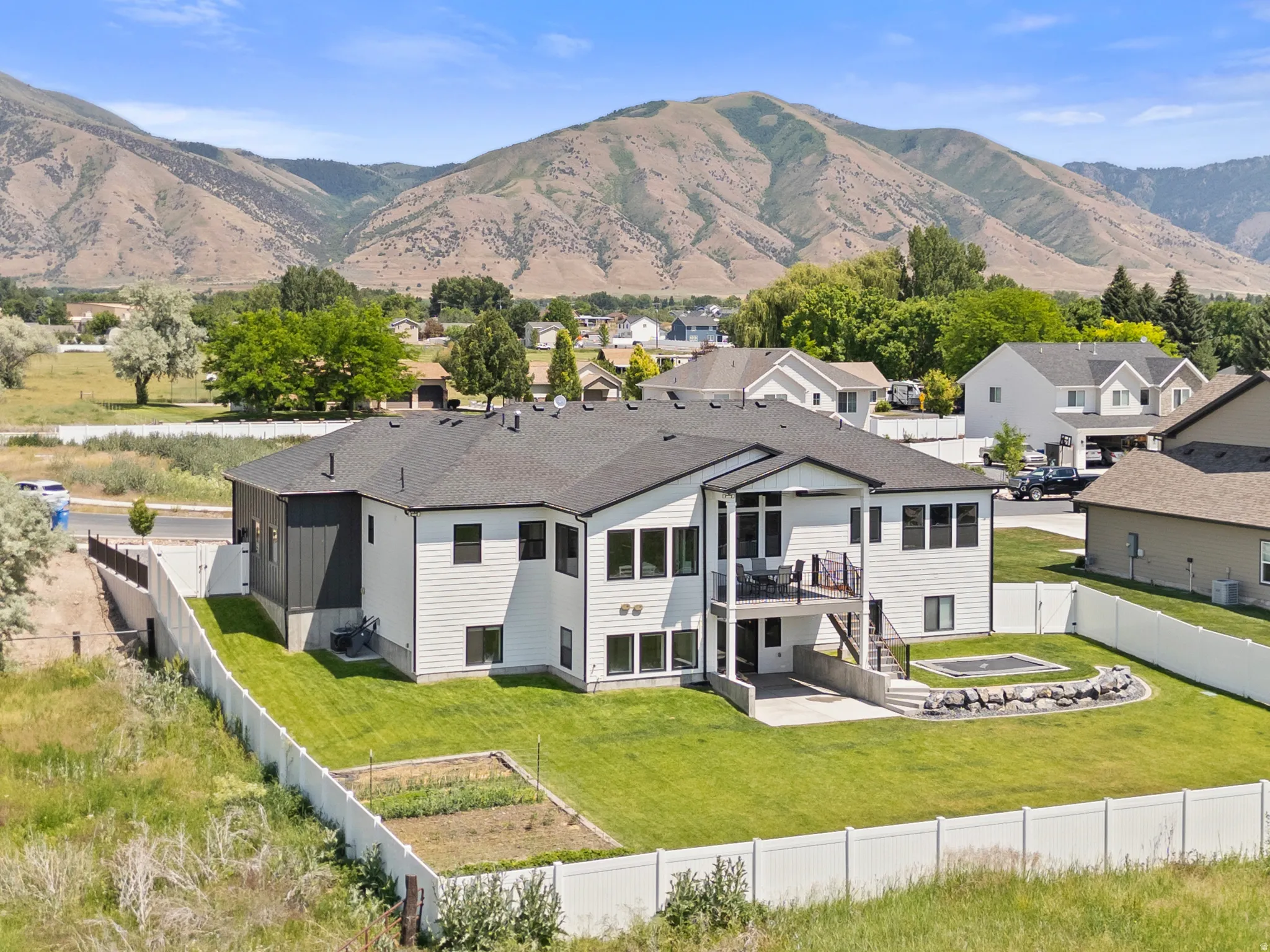 Modern two-story residence featuring a dark shingled roof and contrasting white and dark gray siding