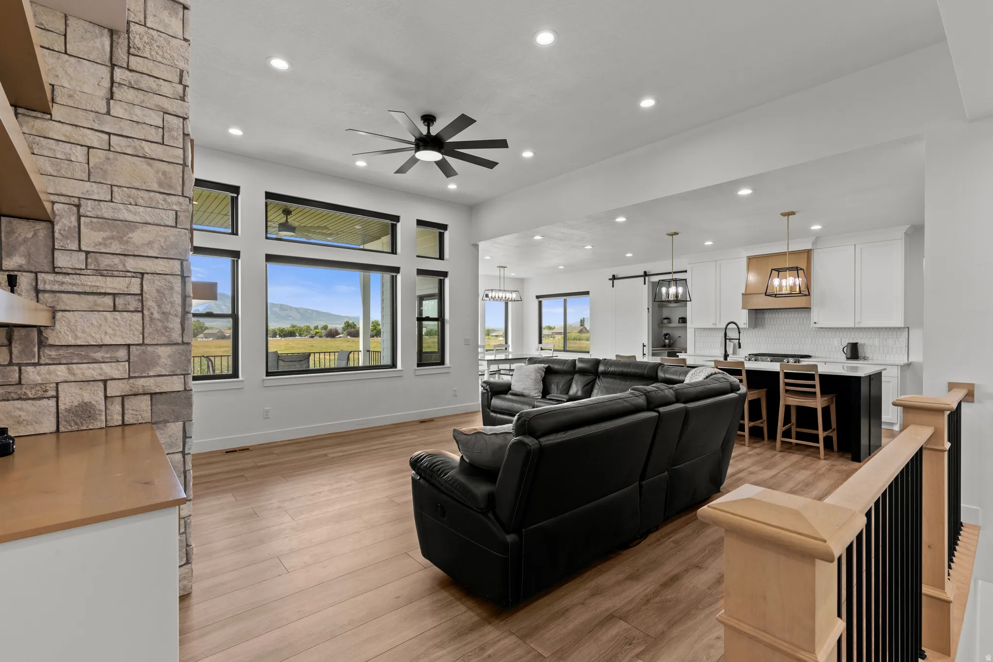 Expansive open-concept living space featuring wood-finish flooring and a stone accent wall
