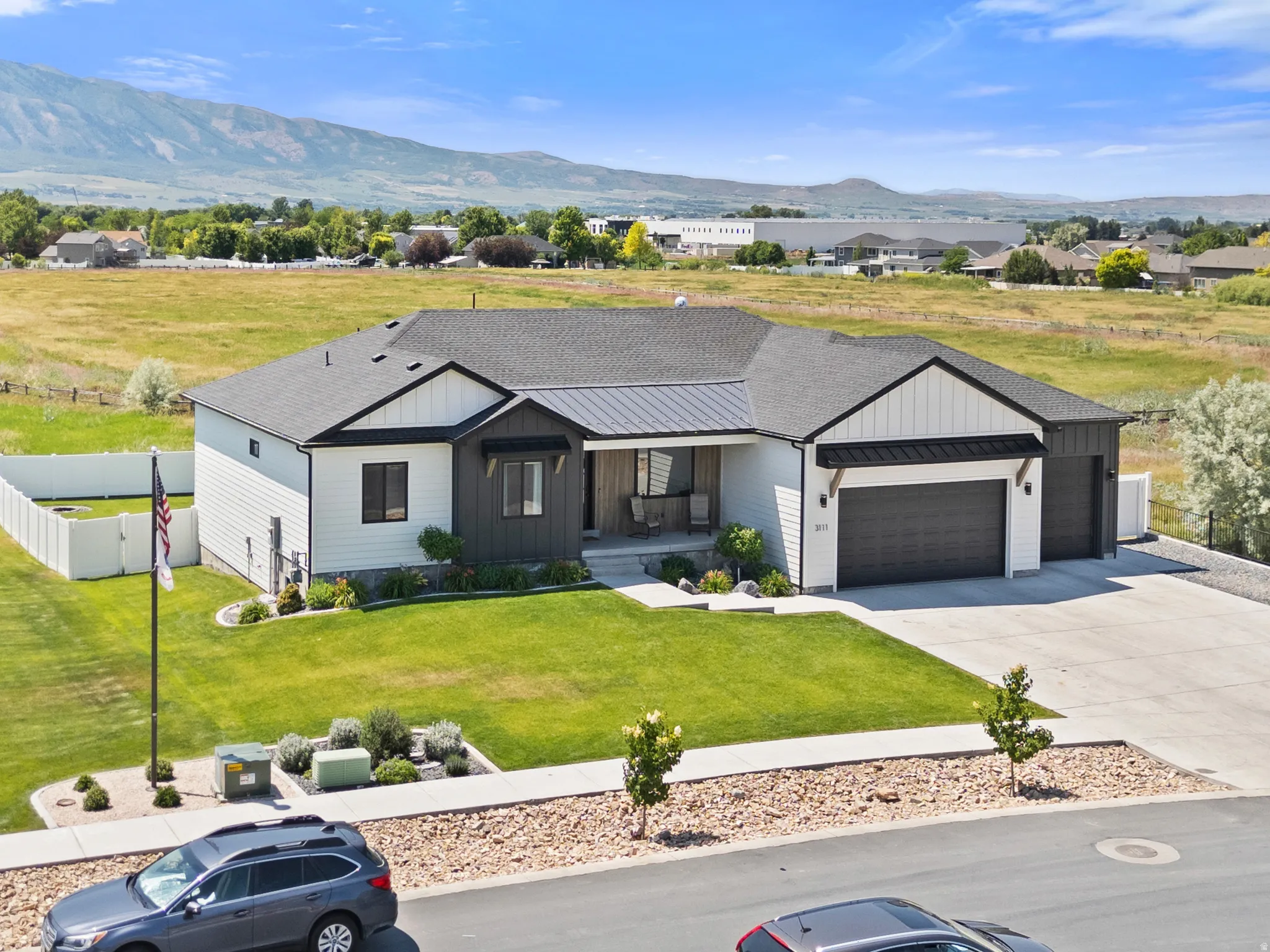 Modern farmhouse-style residence with an attached two-car garage, dark trim accents, and a covered entryway