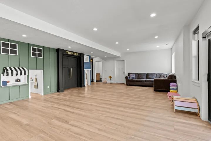 Spacious recreation area featuring wood-finish flooring and recessed lighting
