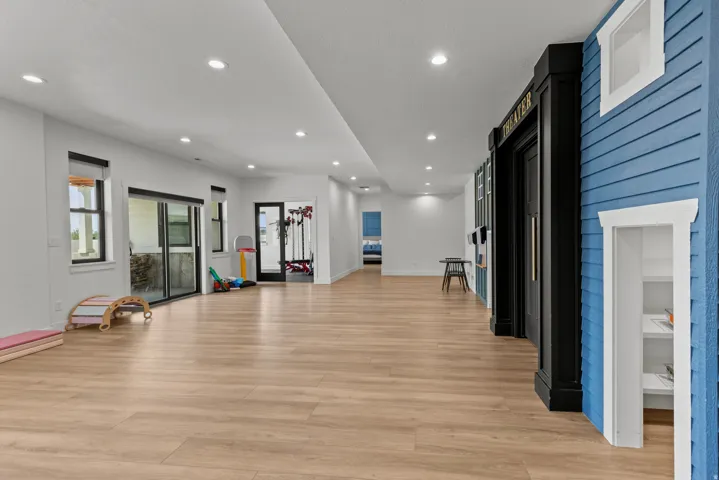 Spacious lower-level area featuring wood-finish flooring, recessed lighting, and white walls